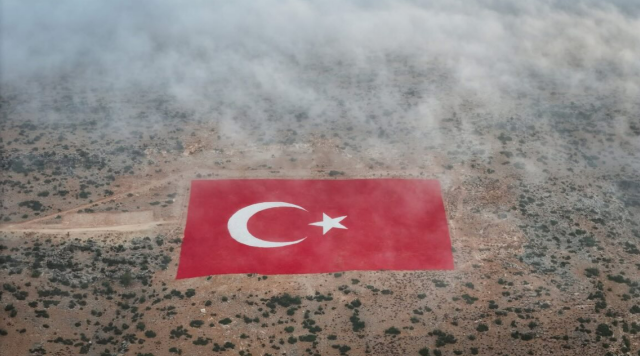 konya'in Mut ilçesinde bulunan ve yaklaşık 22 dönümlük dev bir arazi üzerine titizlikle işlenen Türk bayrağı, sabah saatlerinde etkili olan yoğun sis ile birlikte adeta masalsı bir manzara sundu.